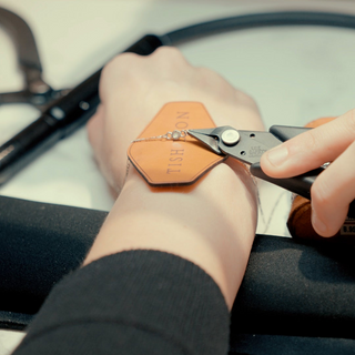 Tish Lyon welding service in progress at John Lewis, Oxford Street, with bracelet being welded onto wrist using precision jewellery tools.