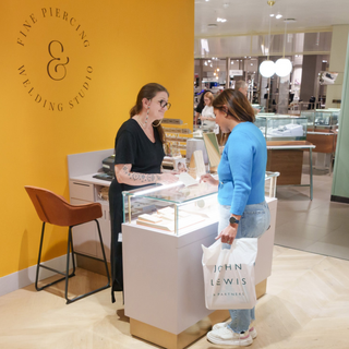 Tish Lyon Fine Piercing & Welding Studio — team member consulting with customer at John Lewis Oxford Street jewellery counter.