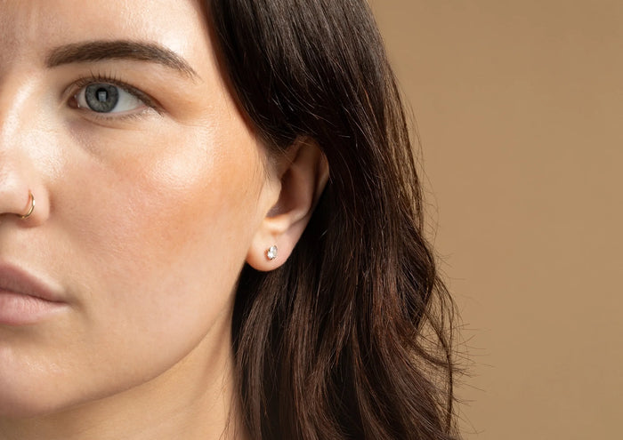 A woman is wearing a moissanite earring