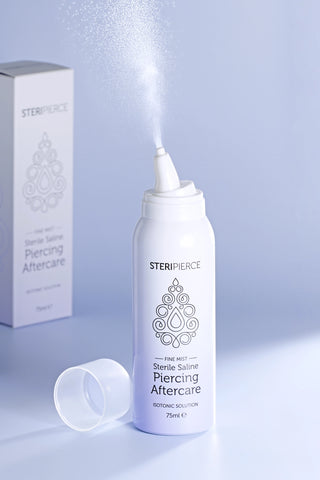 SteriPierce 75ml sterile saline piercing aftercare spray displayed beside its branded retail packaging.